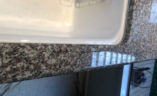 Sink rod failure damage on residential countertop.